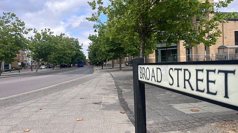 A view of the trees on Broad St in Cambourne, with the street sign in the foreground