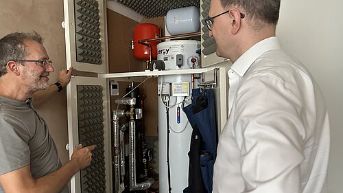 Paul Kershaw showing Ian Sollom MP his heat pump that powers his eco-friendly home