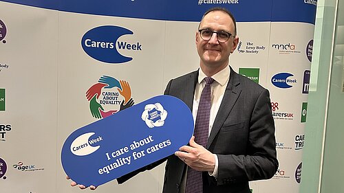 Ian holding a sign saying "equality for carers"